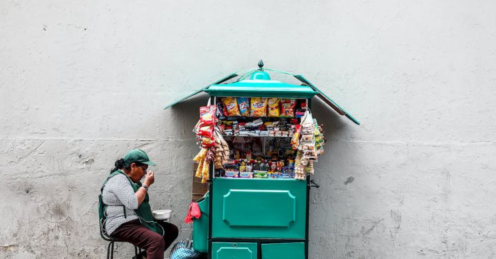 Street Eats - Woman Eating While Seated Next to Mobile Shop Cart