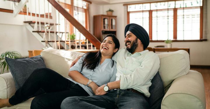 Comedy Acts - Laughing young Indian couple watching comedy movie together at home
