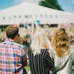 Festival - three person's standing front of field