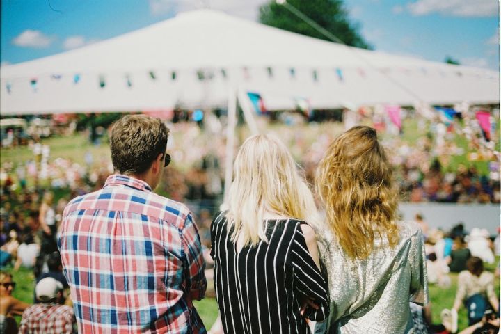 Festival - three person's standing front of field