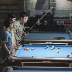 Chill Zone - a group of men standing around a pool table
